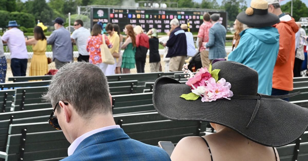people at the saratoga race course, woman in foreground with large floral hat