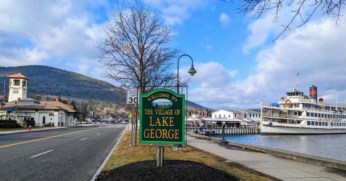 welcome to lake george sign with boat in background