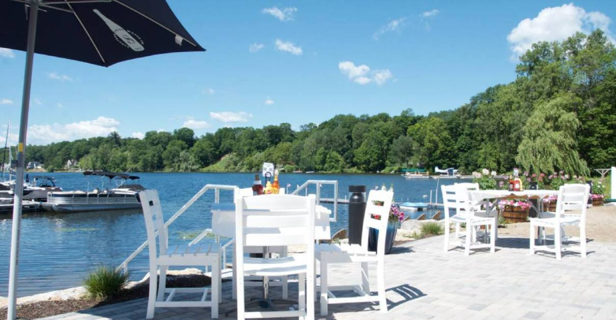 waterfront patio with white tables and chairs