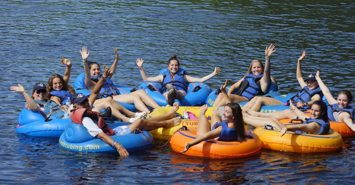 Group of 10 people on tubes in the water in a circular cluster