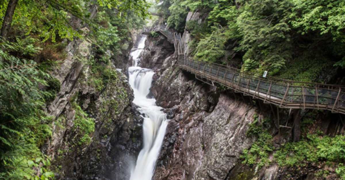 Waterfall with a bridge to the right of it connected to rock