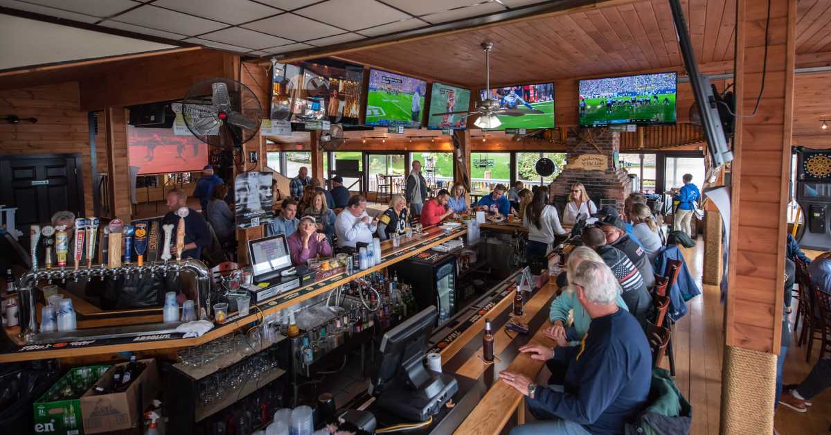 Aerial view of the inside of a bar with sports on the tvs and patrons at the bar