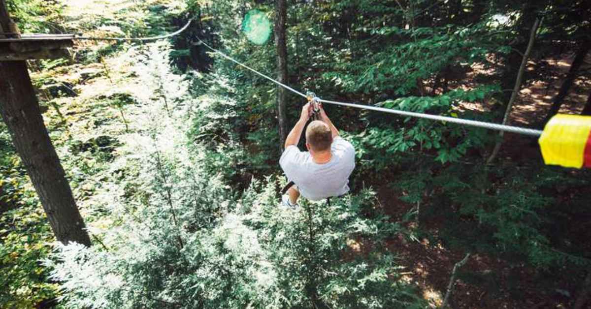 person ziplining through forest