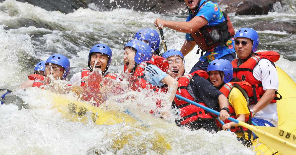 group of people on a raft splashing in waves 