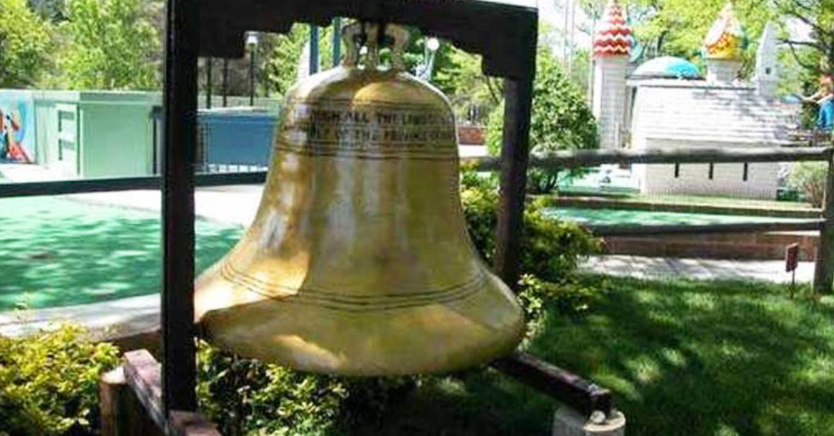 a large bell on a mini golf course