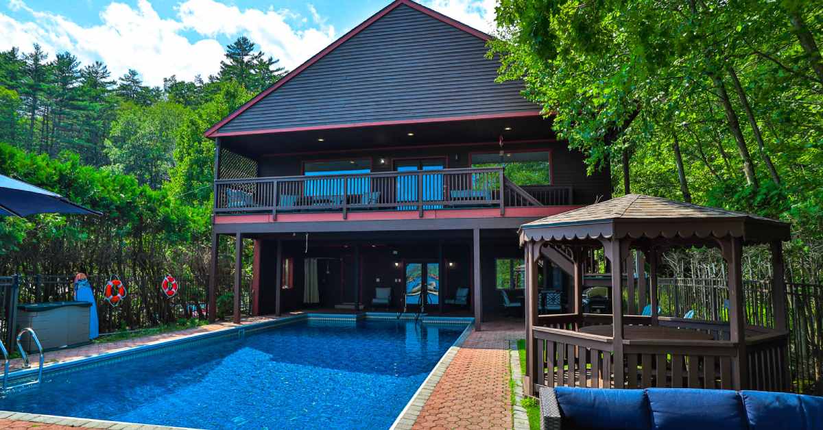 large brown vacation home with outdoor pool and gazebo