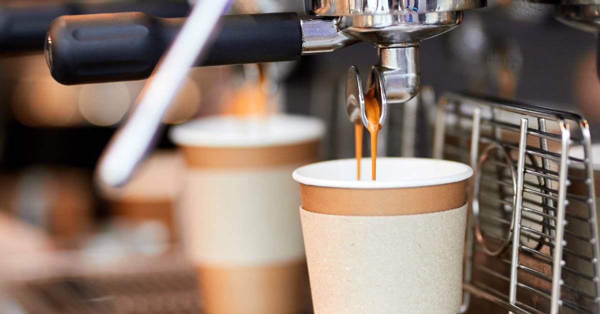 closeup of coffee pouring into cup from machine