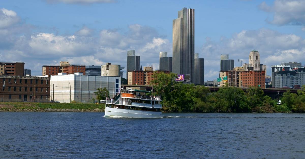 far view of a cruise ship on river with cityscape