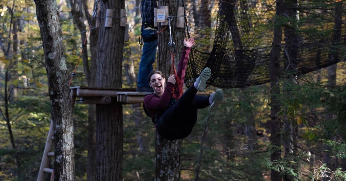 woman attached to harness ziplining 