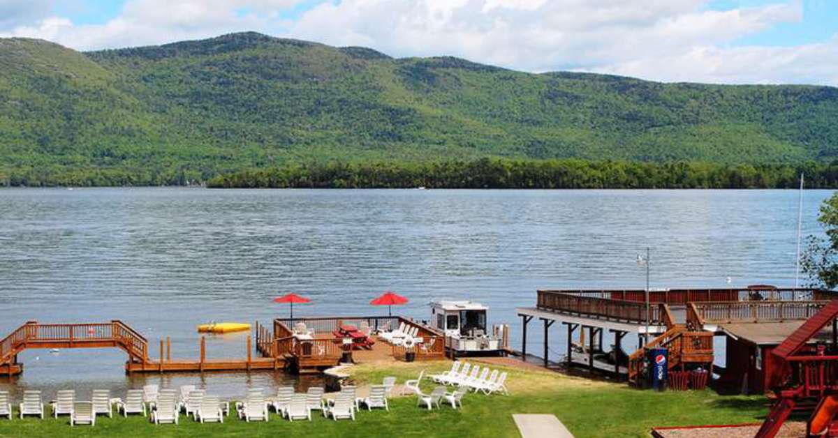 view of a resort beach area, dock and mountains in the back