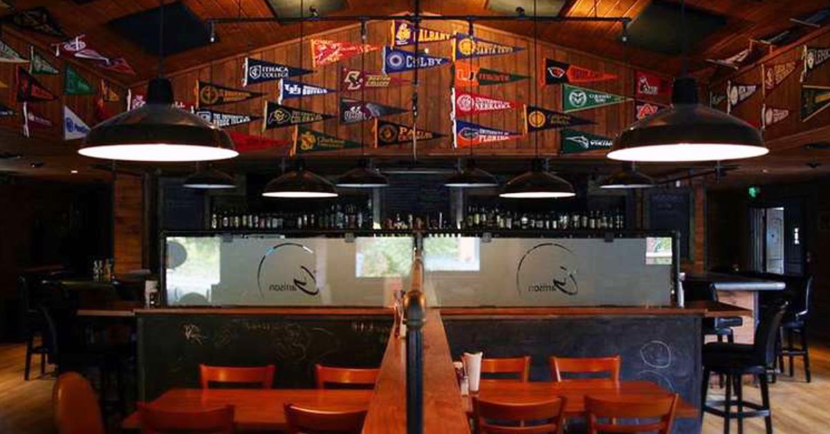 inside of the Garrison Restaurant - tables, chairs, and college pennant flags 