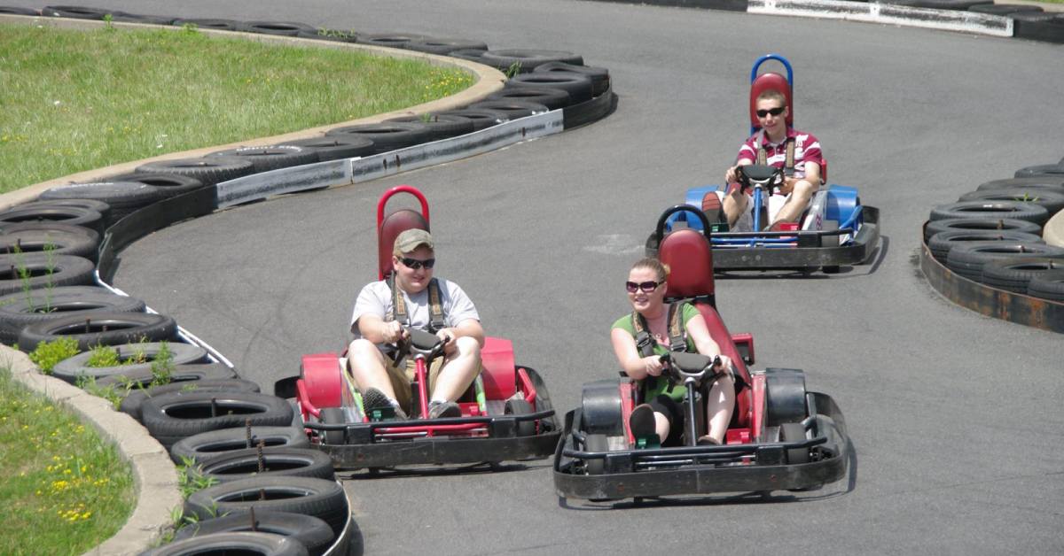 three people driving go karts on track