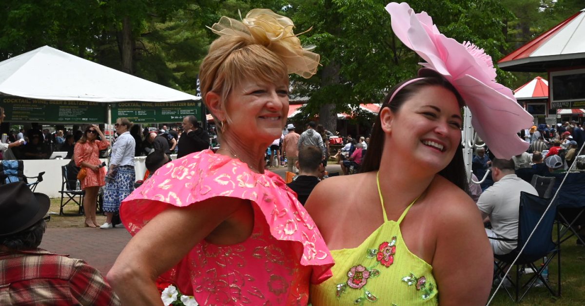 two women at the track with fancy hats