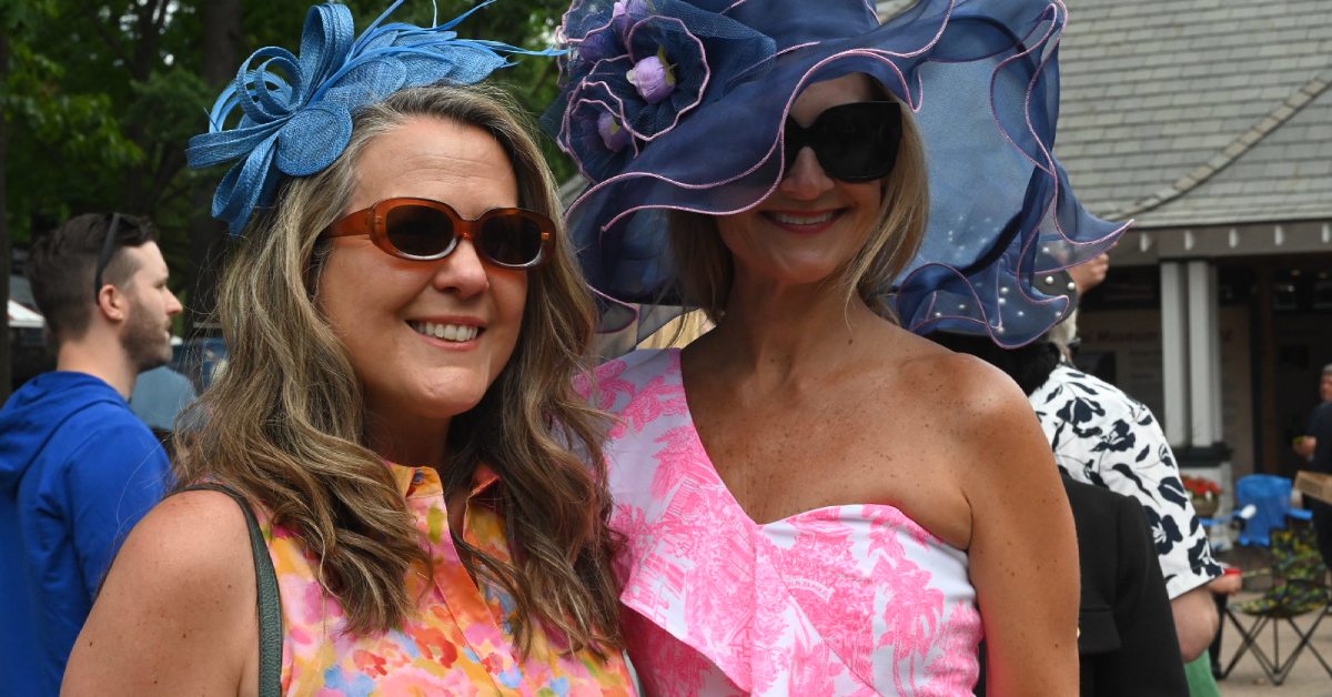 two women at the track with fancy hats on