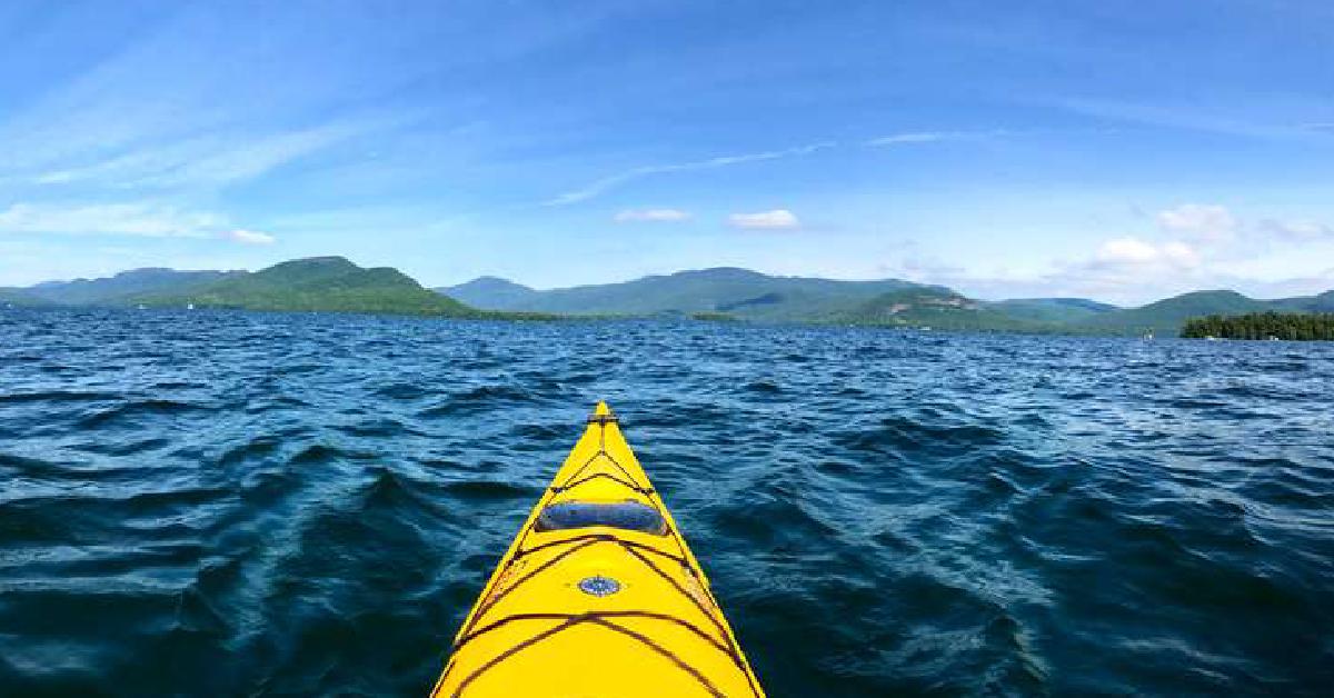 tip of the kayak on the water overlooking the mountains