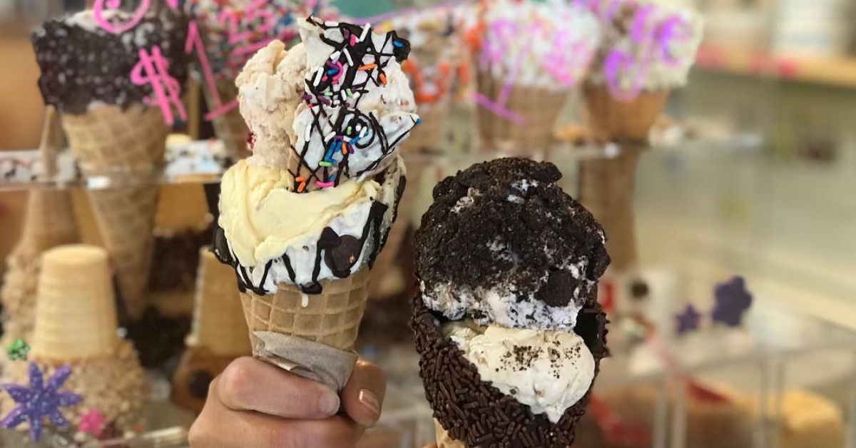 person holding ice cream cone by other cones