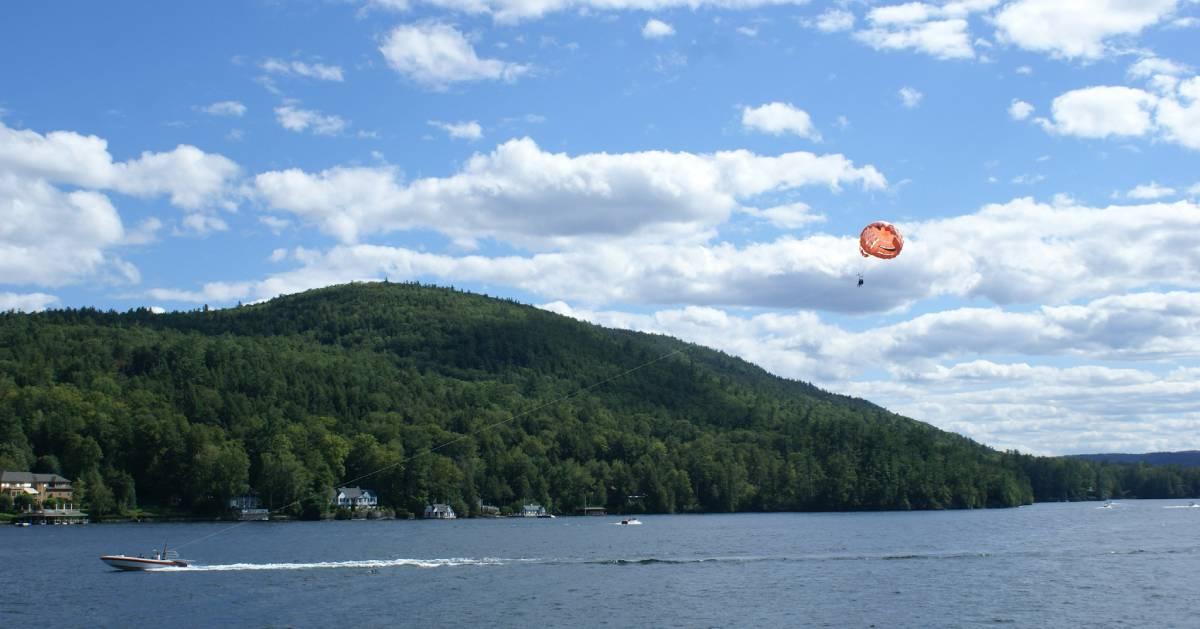 water with mountain and parasail in the air
