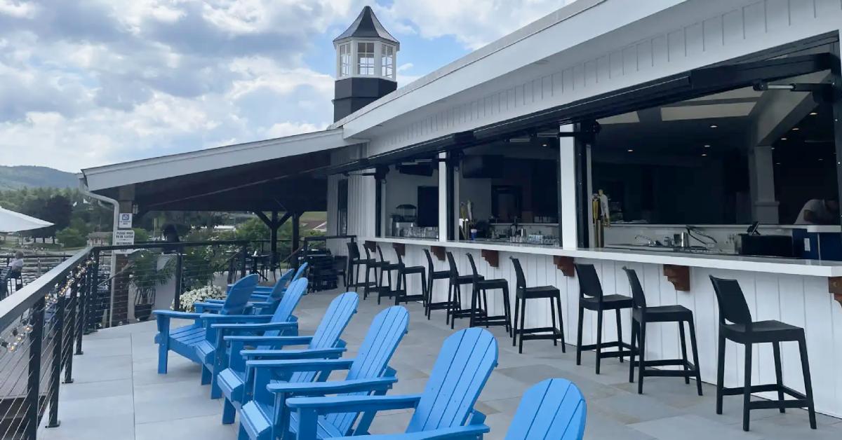 blue adirondack chairs on deck with bar seating nearby