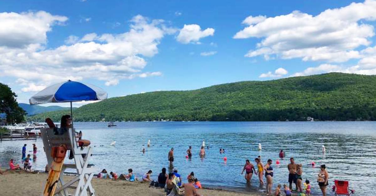 beach goers and lifeguard with water and mountain view 