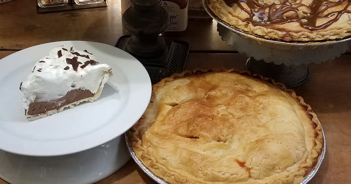 Various pies and slices of pie on plates 