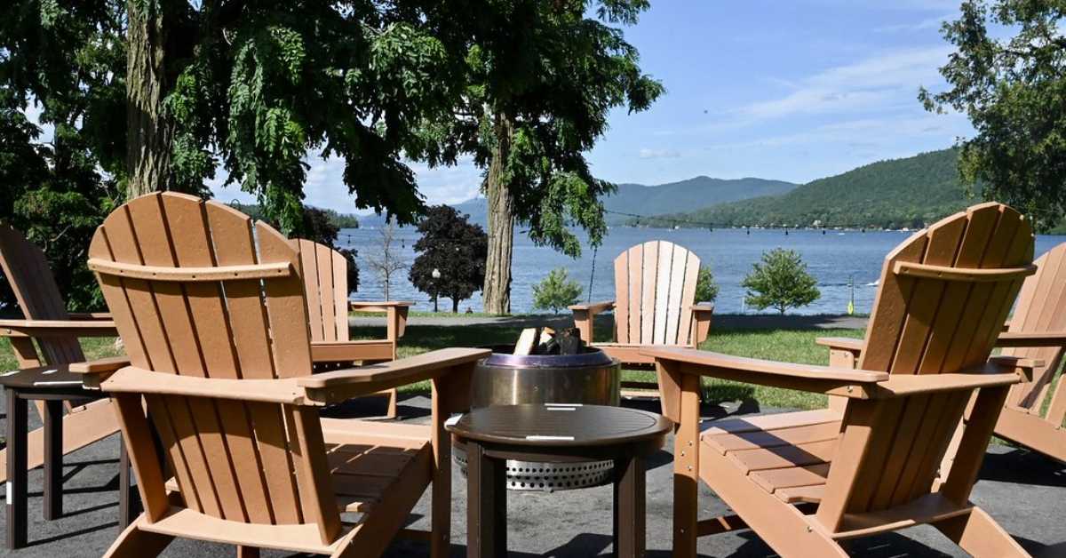 Adirondack Chairs surrounding a firepit with a lake in the background