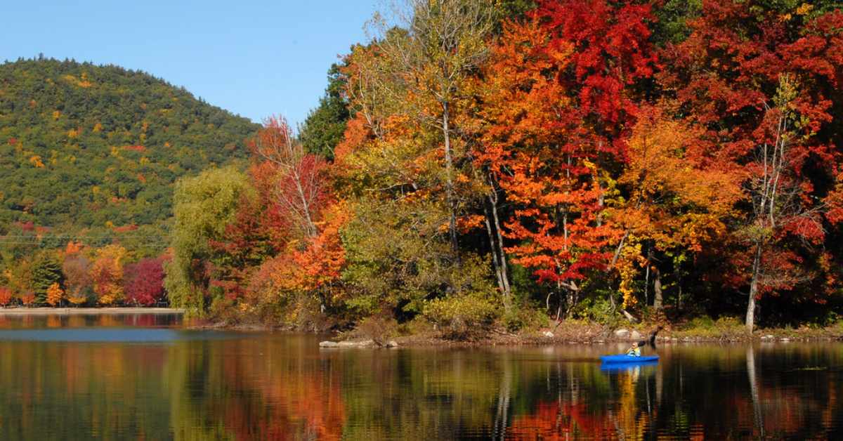 Lake with red orange and yellow trees surrounding it