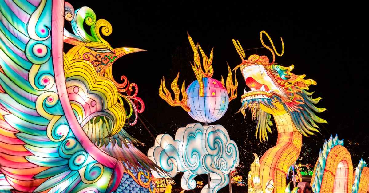 dragon, bird, cloud, and ball shaped chinese lanterns glowing in the dark sky