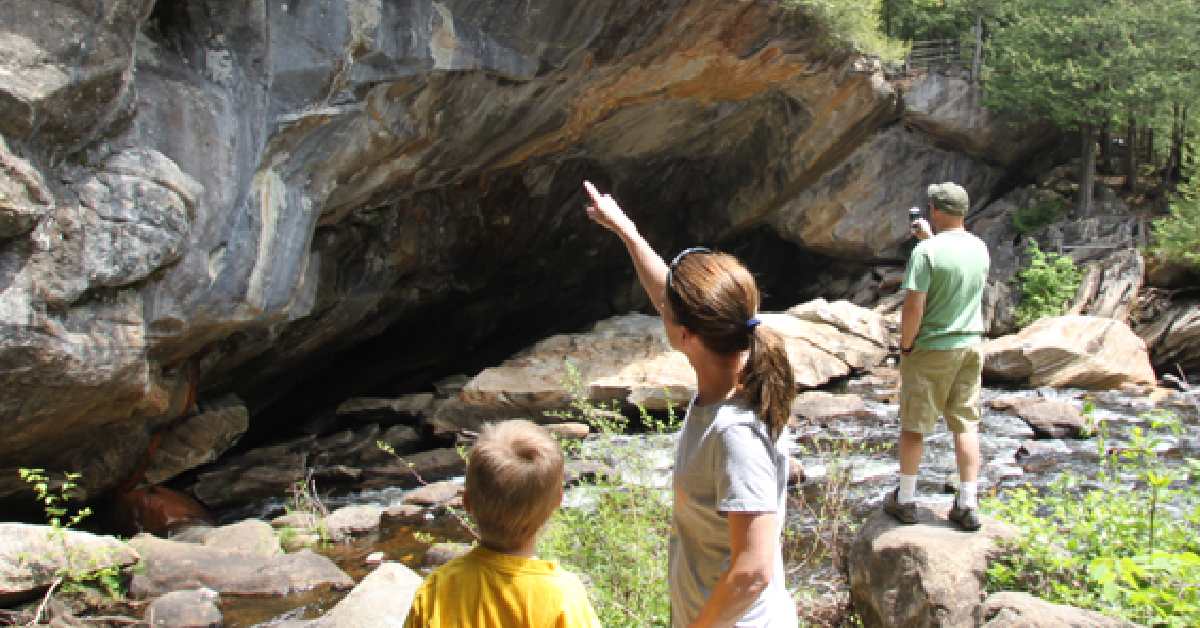 woman pointing at natural stone bridge