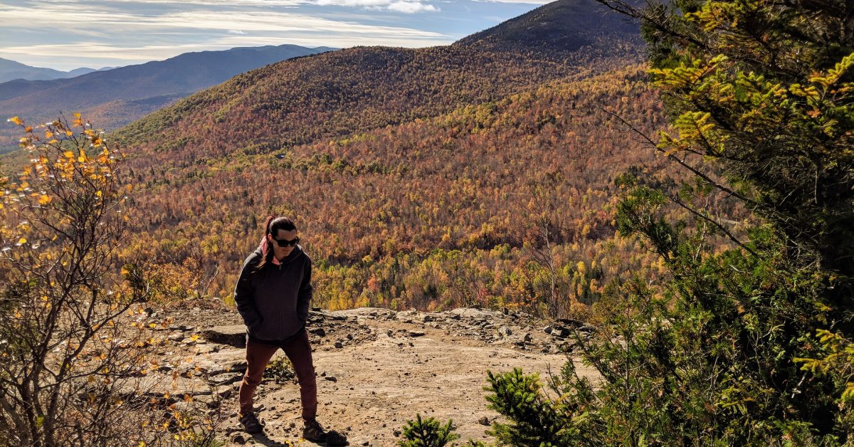 woman hikes at cobble lookout in the fall