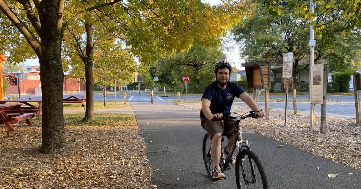 man bikes on warren county bikeway in the fall