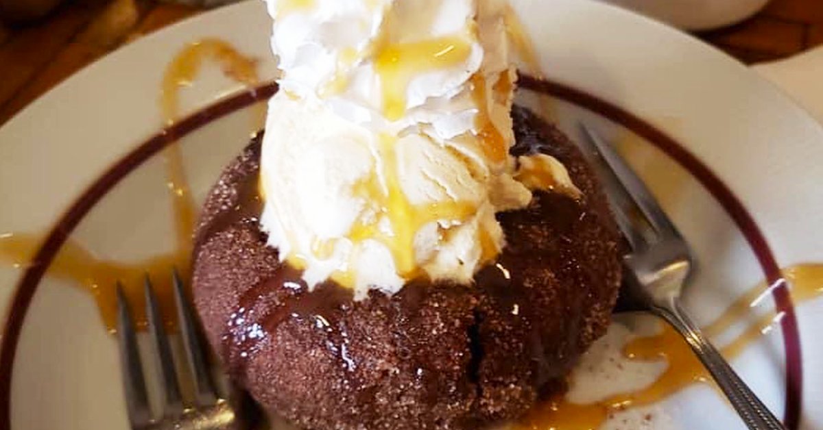 cinnamon donut topped with ice cream, whipped cream, and caramel sauce