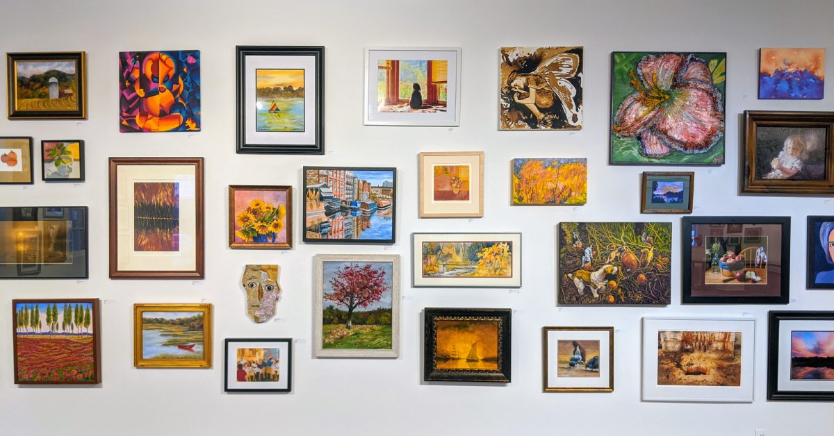 many paintings on a wall at saratoga arts