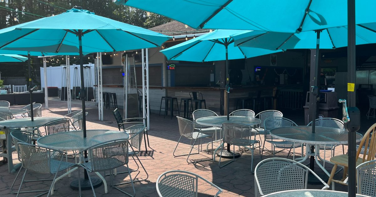 patio with tables, chairs, and blue umbrellas