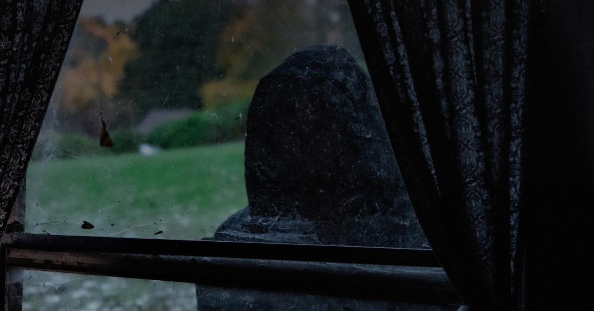 cloaked figure at a window