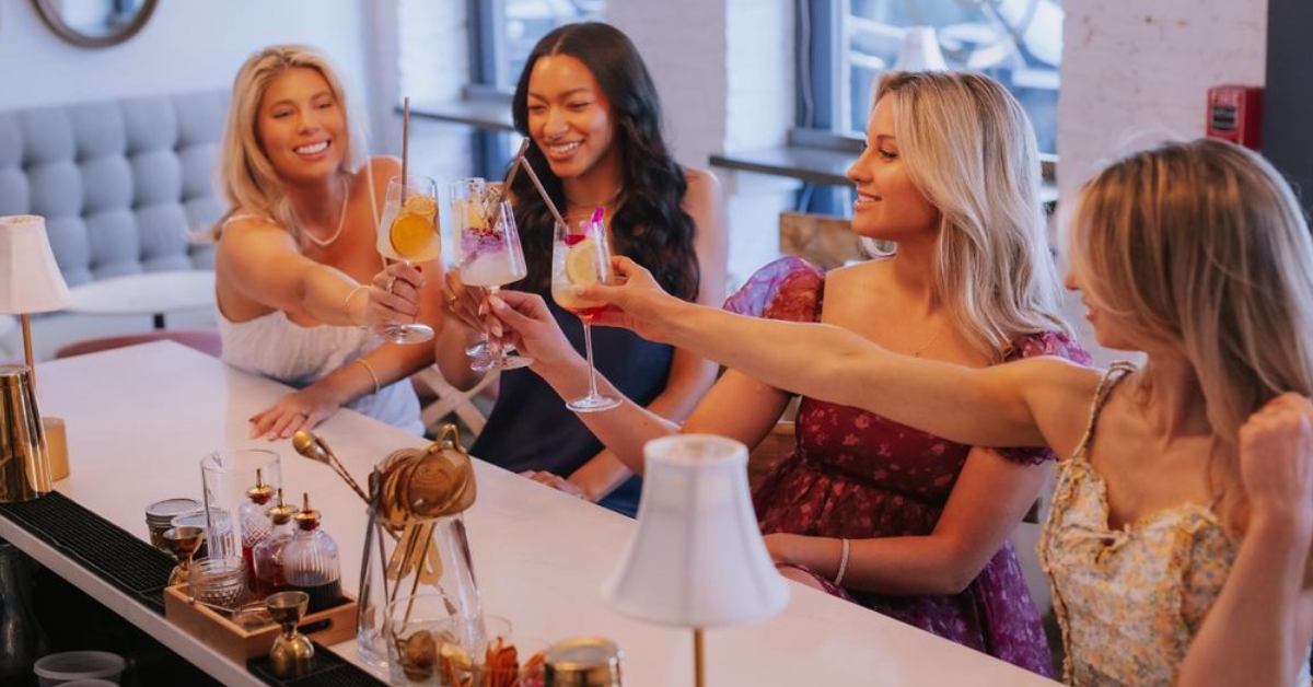 group of women cheersing with drink glasses at a bar