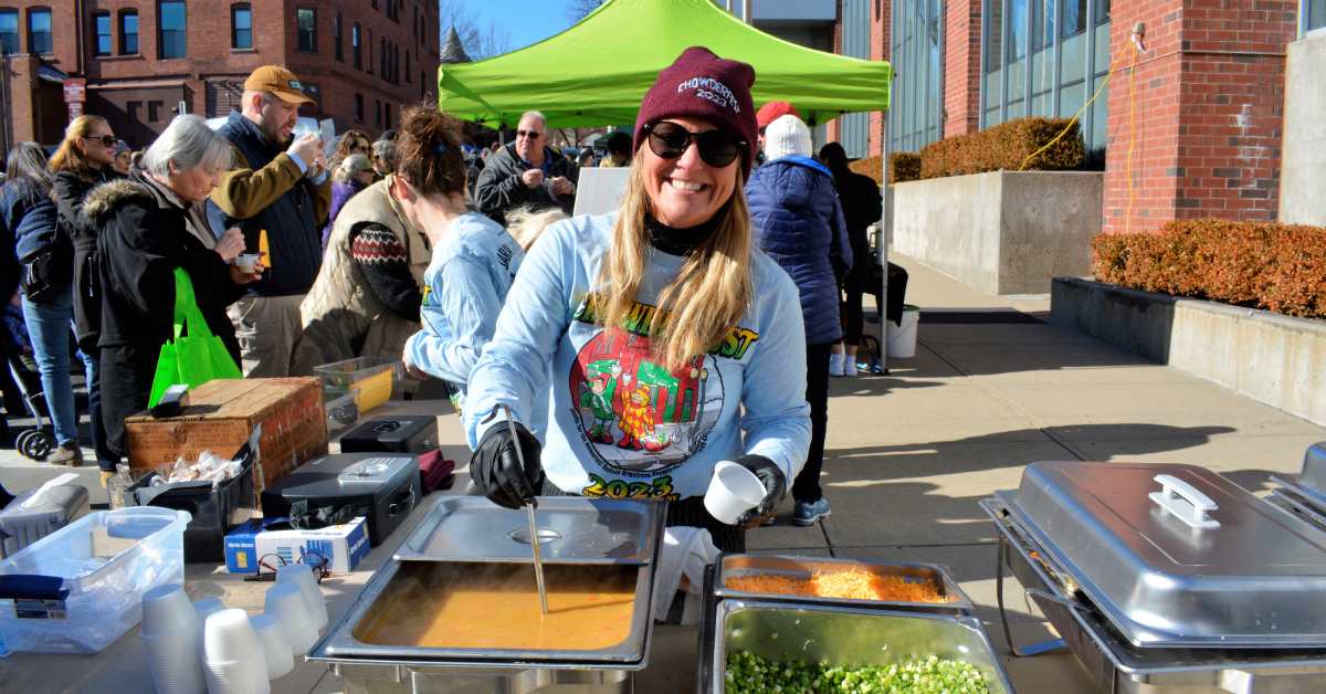 woman serving chowder at an outdoor Chowderfest event