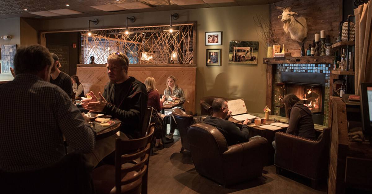 lounge seating area in a restaurant with a fireplace in the corner