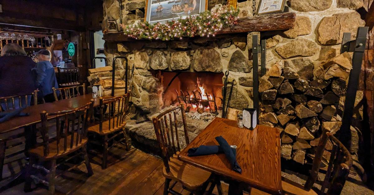 fire in fireplace at log jam restaurant near table for two