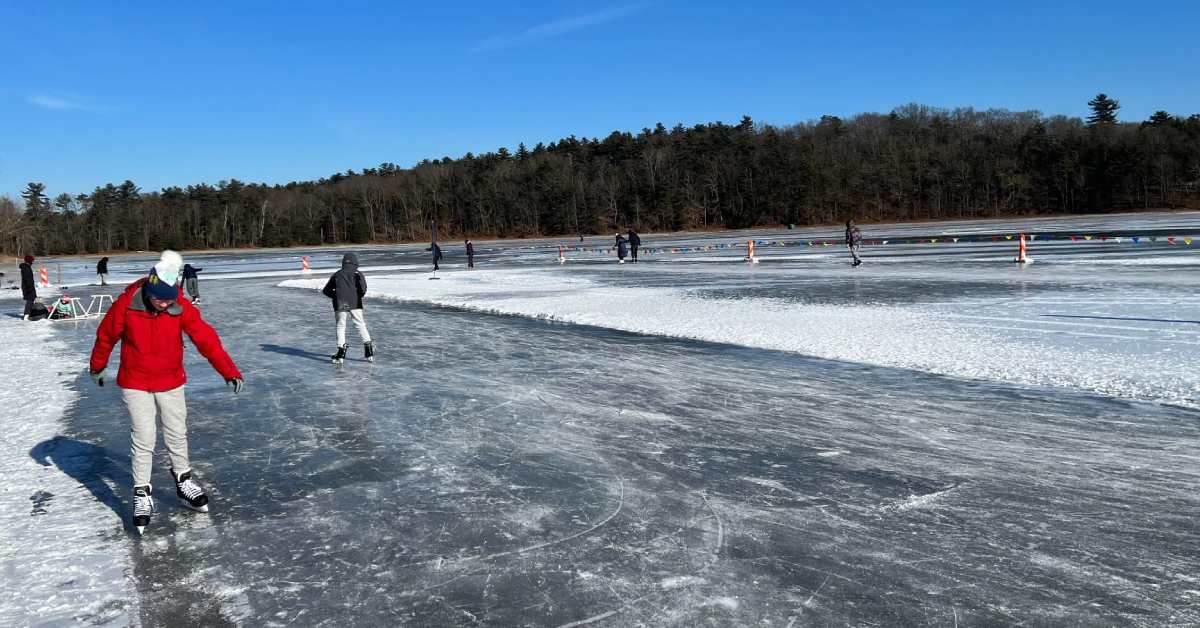 people ice skating on frozen pond