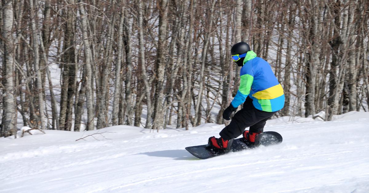 a snowboarder in a multi color blue and yellow jacket