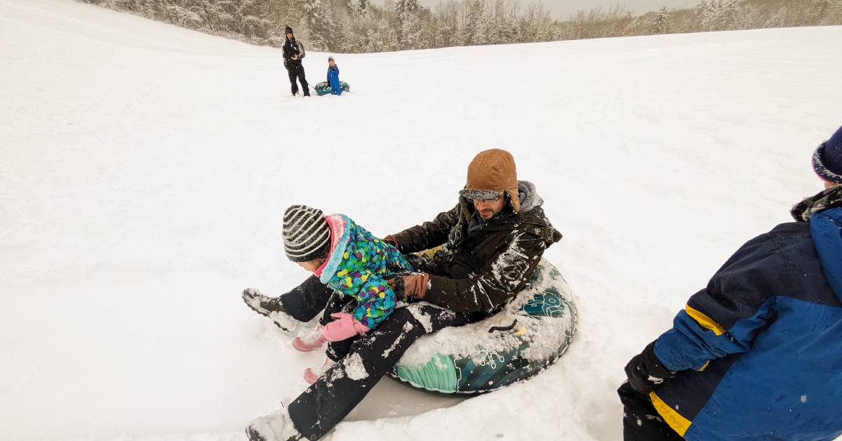 dad with girl on snow tube