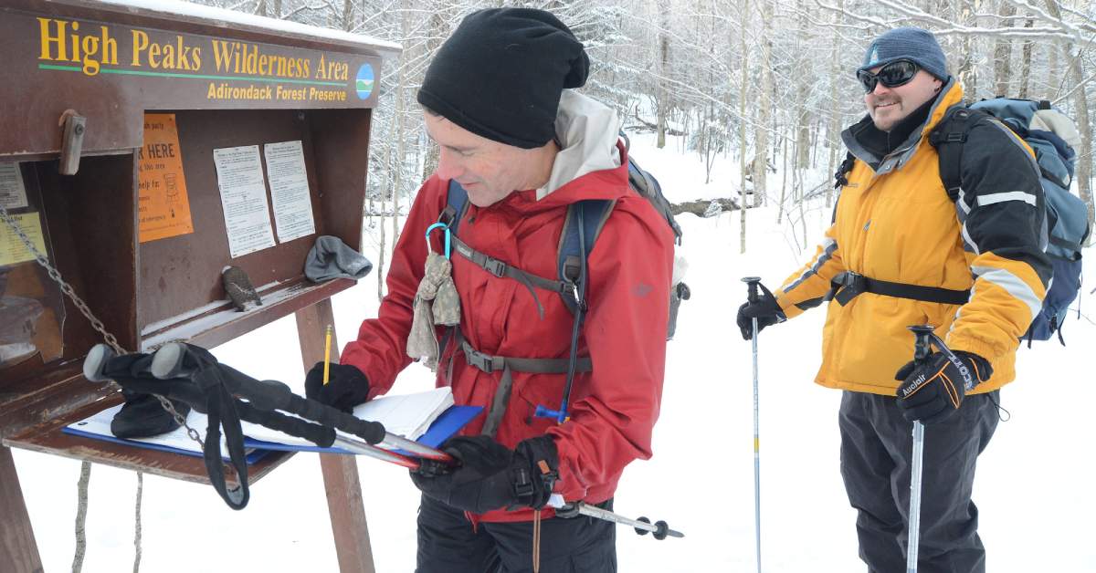 two men at a hike trailhead in winter