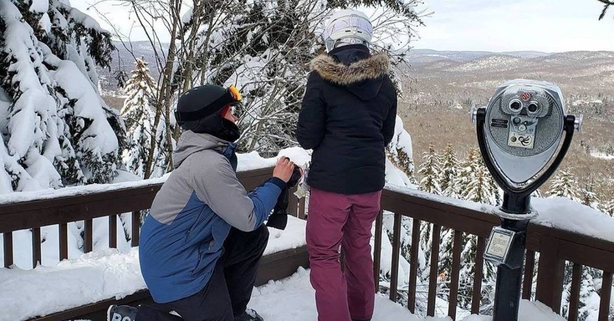 guy proposes to girl on balcony with ski gear on it