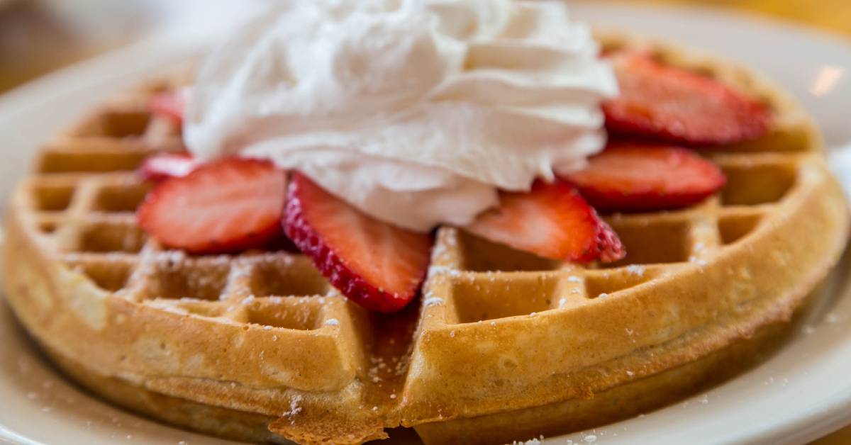 strawberries and whipped cream on waffles