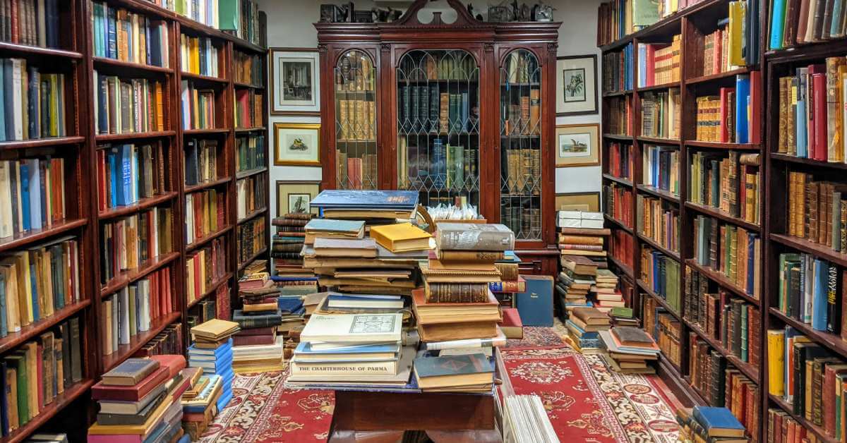 bookstore with books on shelves, a table, and in piles on the floor