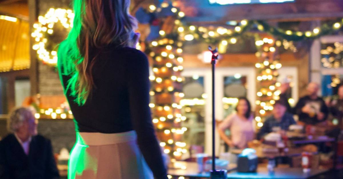 woman singing at festively decorated lake george beach club