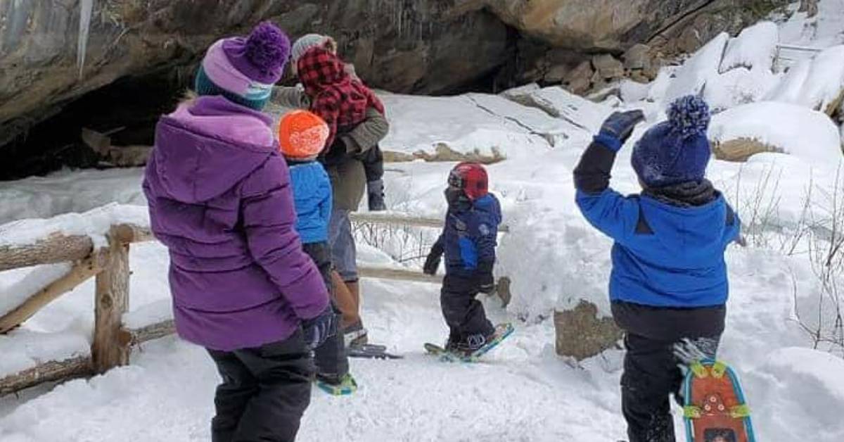 family snowshoeing at natural stone bridge and caves