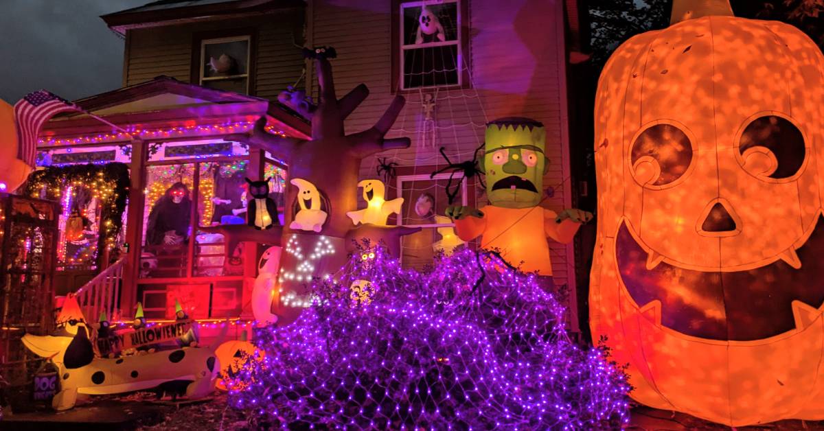 house decorated for halloween with giant jack-o-lantern to the side