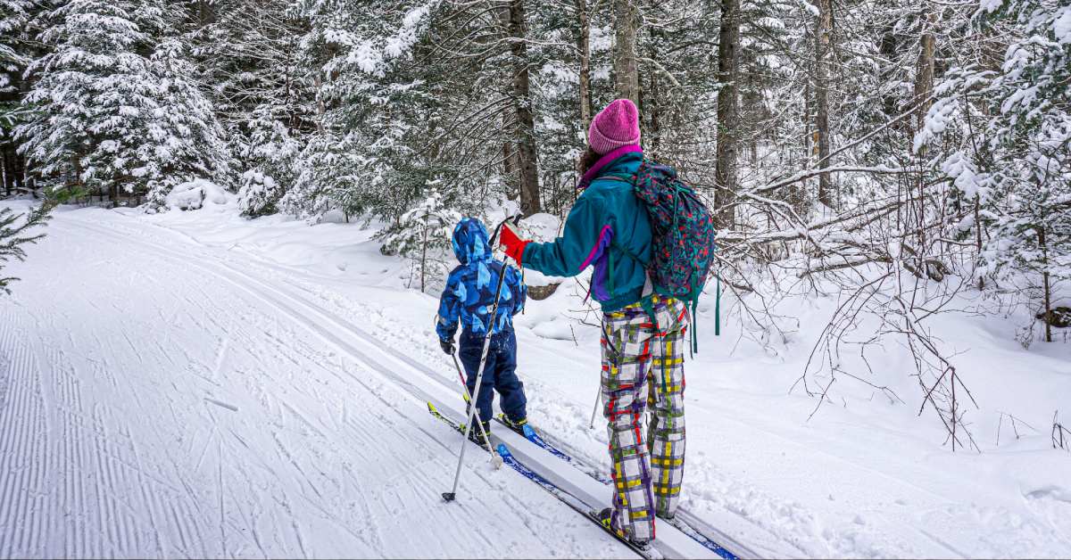 parent and child on a cross country ski trail