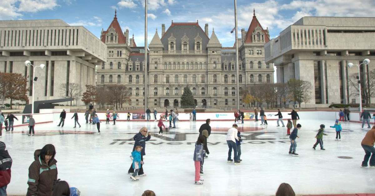 the Empire State Plaza ice skating rink with ice skaters on it
